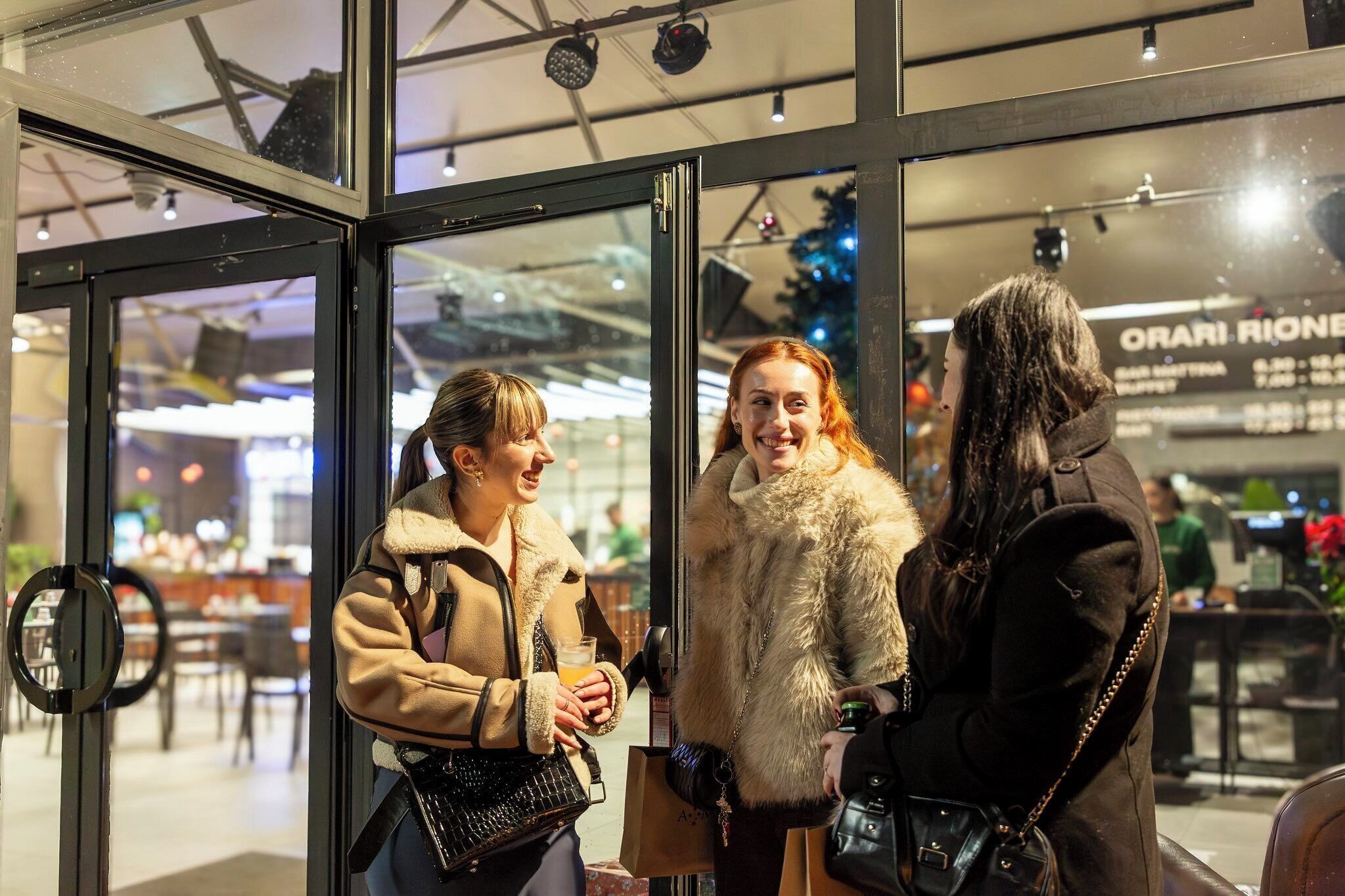 A group of people standing at a glass door entrance of a building.