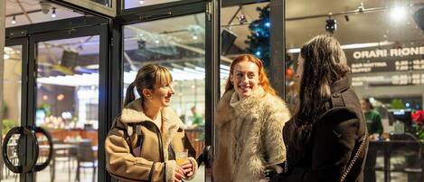 A group of people standing at a glass door entrance of a building.