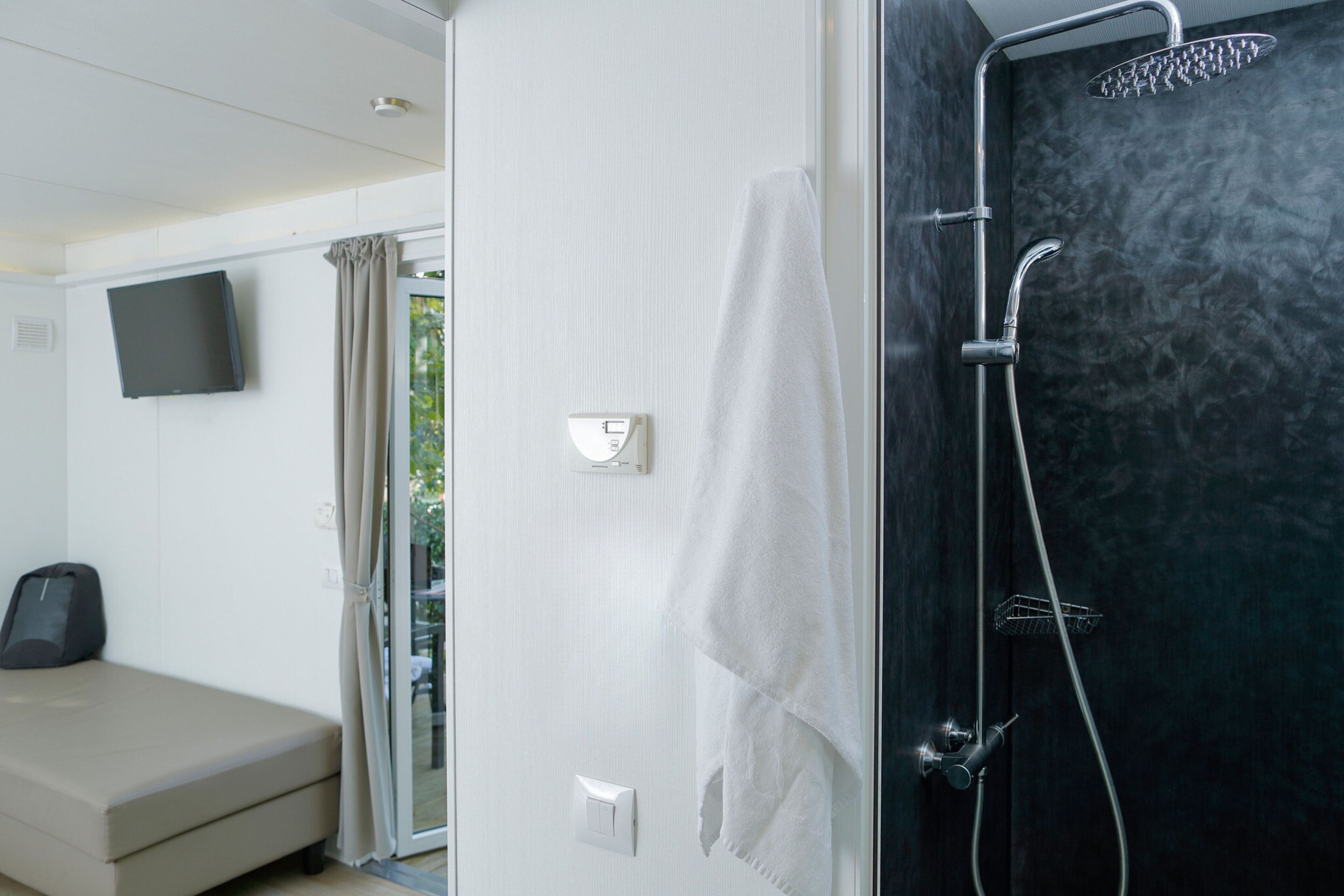A modern bathroom with a shower, a toilet, and a sink.
