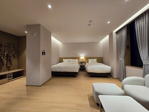 A hotel room with two beds, a desk, a chair, and a small seating area. - Tria Hotel (Seoul)