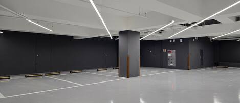 Un área de estacionamiento interior espaciosa y moderna, con líneas limpias y diseño minimalista.