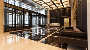 A spacious lobby with a reflective floor, large windows, and a modern sofa. - The Riverside Hotel (Seoul)
