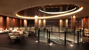 A modern hotel lobby with a circular central area, seating arrangements, and a view of the cityscape. - The Riverside Hotel (Seoul)
