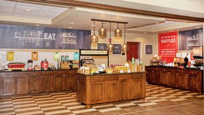 A breakfast bar with a checkered floor, wooden cabinets, and hanging pendant lights.