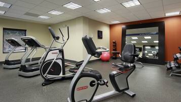A gym with treadmills, an elliptical, a rowing machine, and free weights.