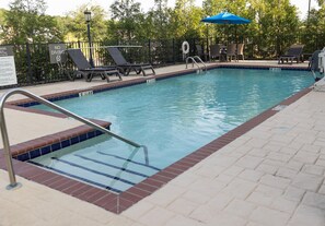 A swimming pool with a tiled edge, a metal ladder, and lounge chairs. - Hampton Inn Winfield (Winfield)