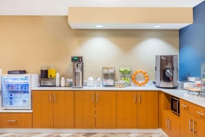 A hotel breakfast area with a refrigerator, coffee machine, and a microwave. - AmericInn by Wyndham Prairie du Chien (Prairie Du Chien)