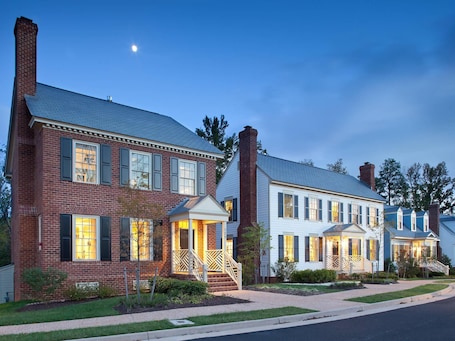 A row of two-story houses with brick and white siding, featuring front porches and chimneys.