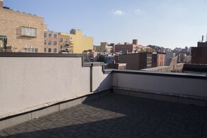 A rooftop terrace with a view of a cityscape.