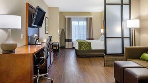 Ein Hotelzimmer mit Schreibtisch, Stuhl, Bett und einer Couch.