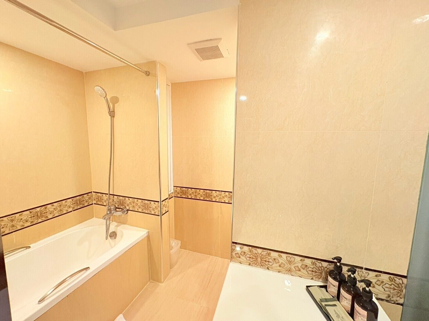Un baño moderno con bañera, ducha y tocador con artículos de aseo.