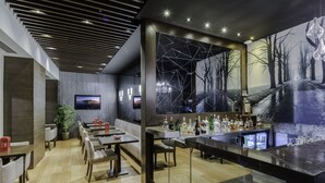 A modern bar area with a long counter, seating, and a large wall mural. - Levni Hotel & Spa - Special Class (Istanbul)