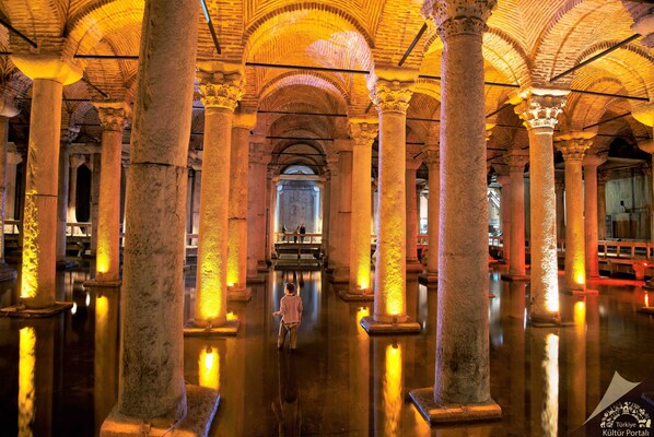 A spacious interior with high ceilings and large columns, reflecting a historical architectural style.