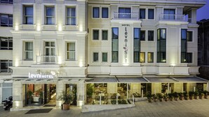 A hotel with a modern facade, multiple windows, and a visible entrance with a sign. - Levni Hotel & Spa - Special Class (Istanbul)