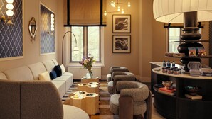 Una sala de estar moderna con un sofá, sillones, una mesa de centro y una mesita auxiliar con adornos.