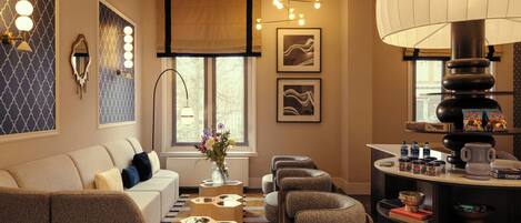 A modern living room with a sofa, armchairs, a coffee table, and a side table with decorative items.