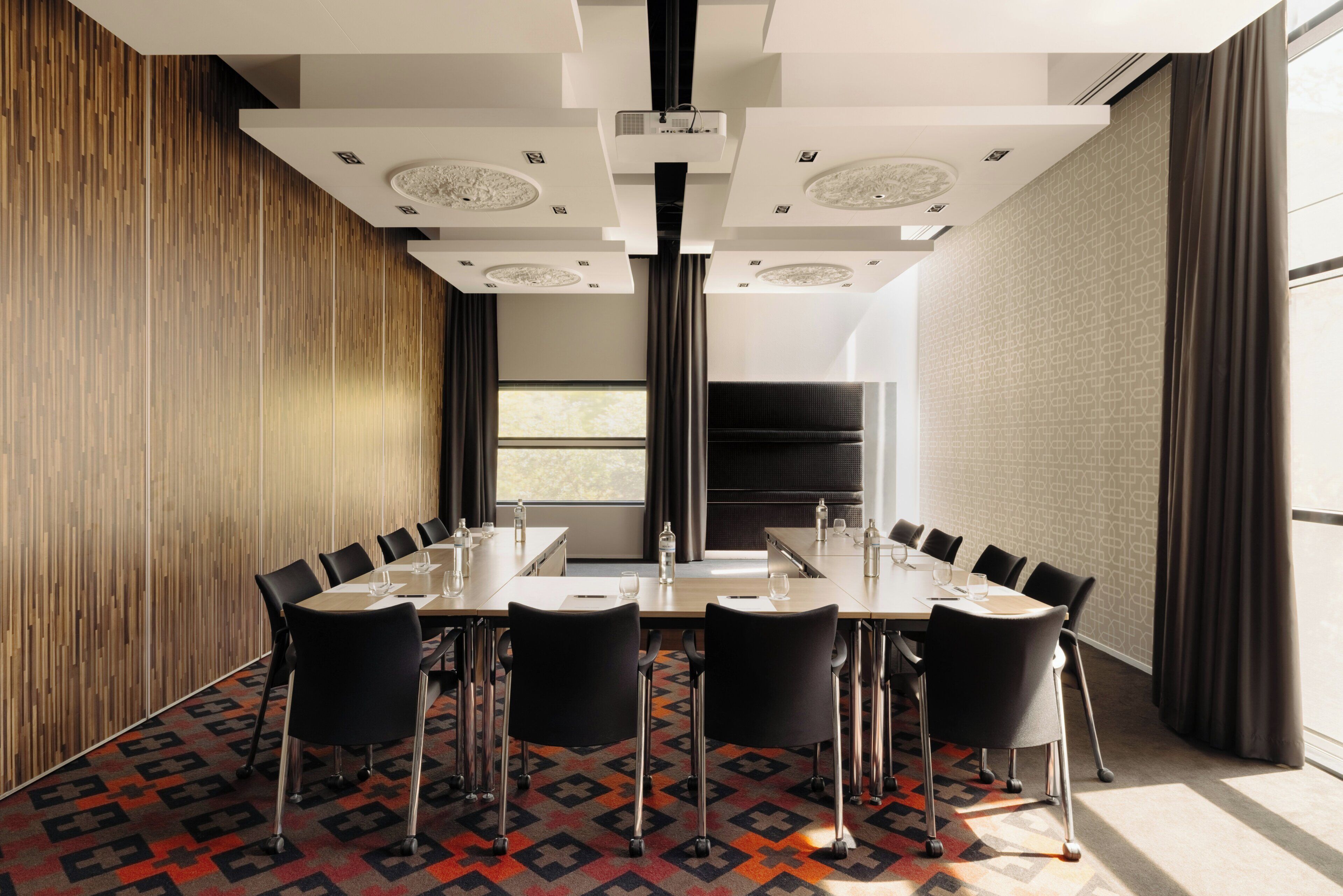 Une salle de conférence équipée d’une longue table, de chaises et d’un projecteur.