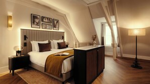 A bedroom with a bed, bedside tables, a desk, a lamp, and framed pictures on the wall. - The Manor Amsterdam (Amsterdam)