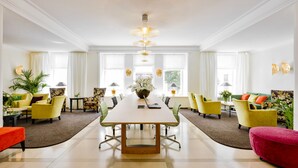 A spacious room with a long table, multiple chairs, and a vibrant color scheme. - Hotel Reutemann - Seegarten (Lindau)