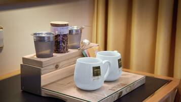 A tray with two white mugs and two containers on a wooden table.