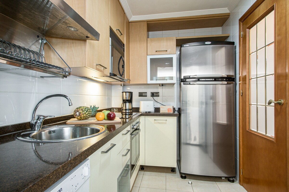 A modern kitchen with stainless steel appliances, a built-in oven, and a coffee maker.