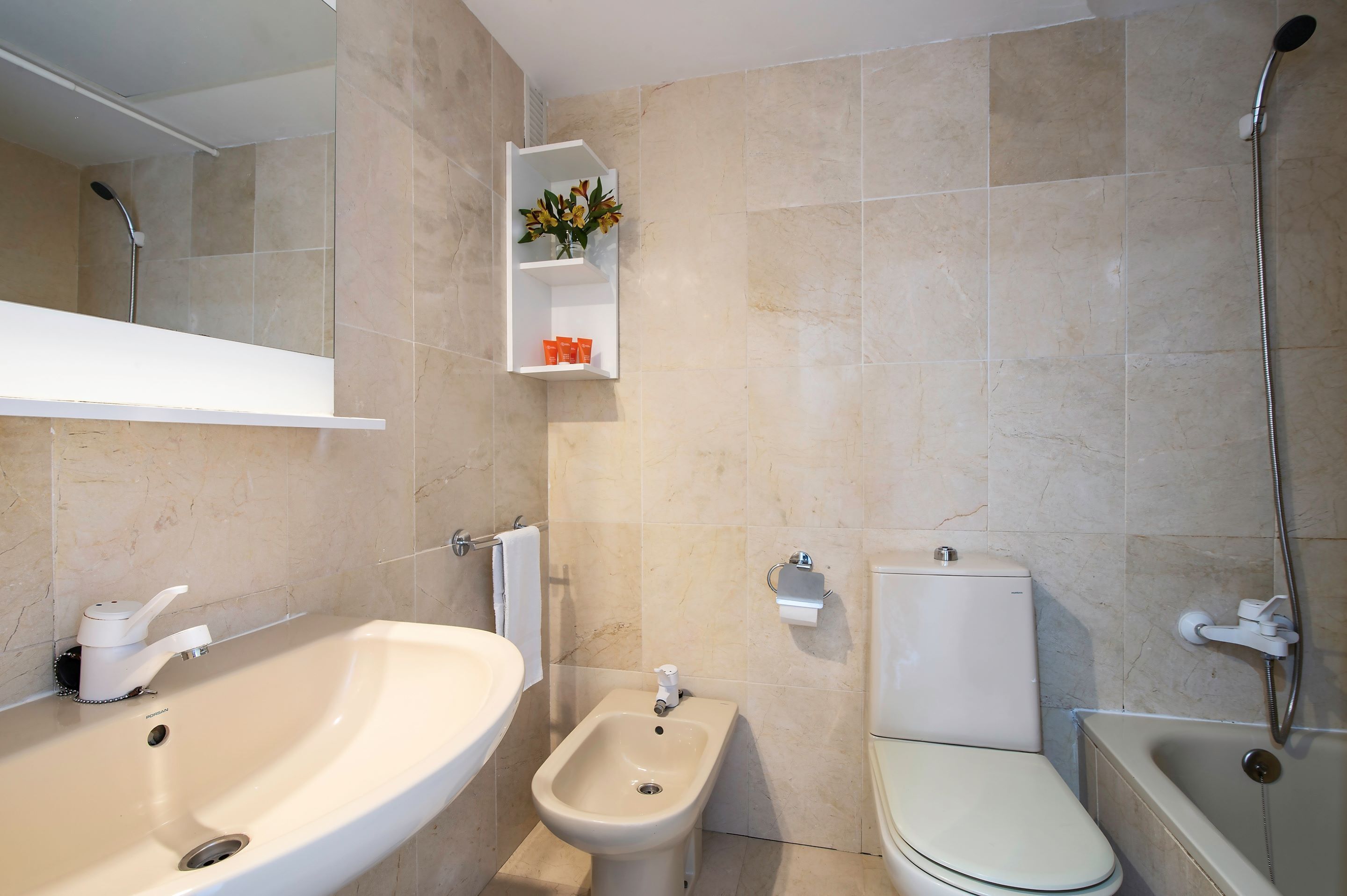 Une salle de bain équipée d’un lavabo, d’un bidet, de toilettes et d’une baignoire.