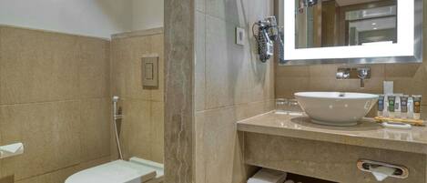 Ein Badezimmer mit Toilette, Waschbecken, Spiegel und Dusche.