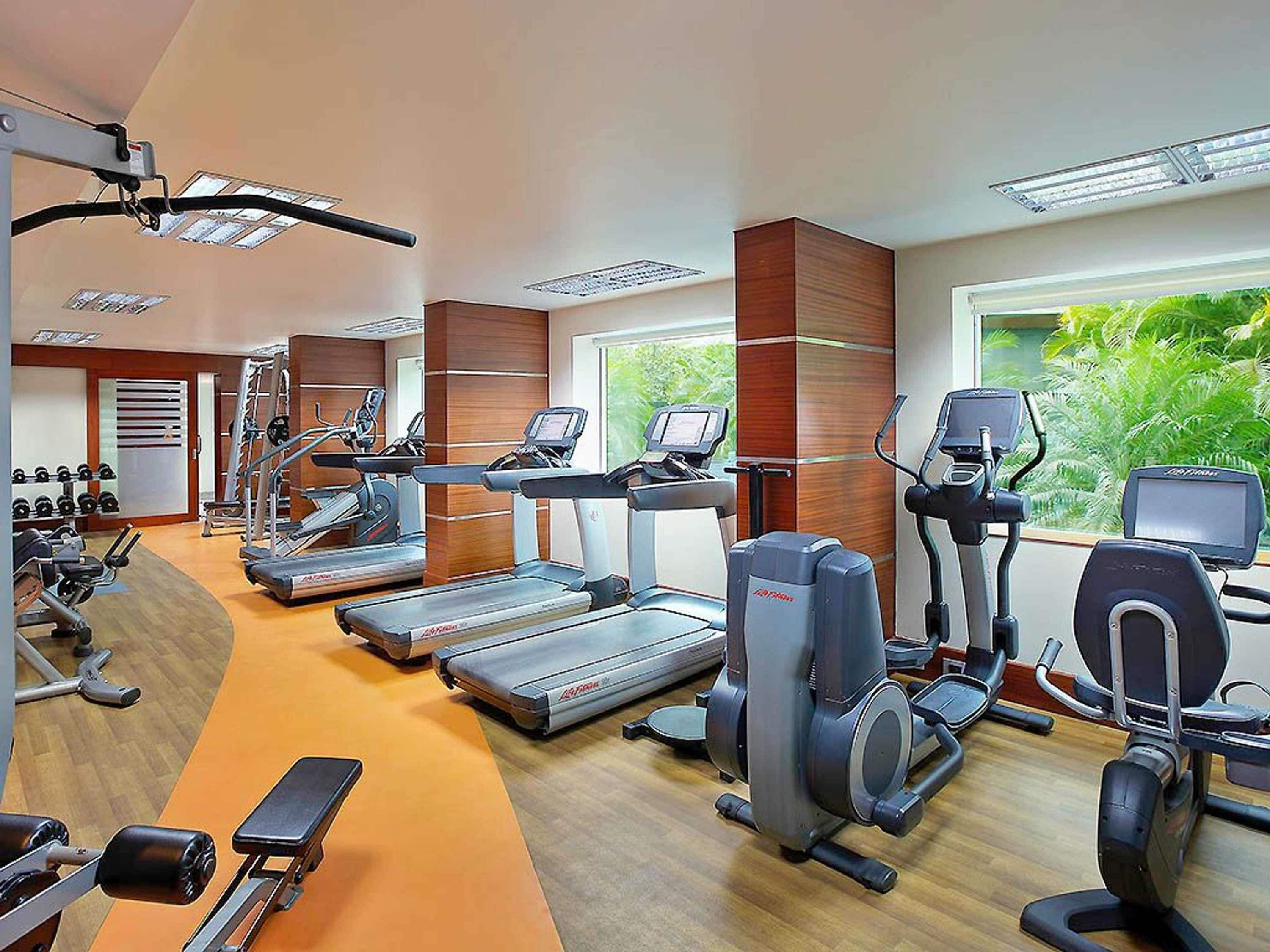 A gym with treadmills, elliptical machines, and weight equipment.