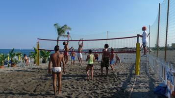 Un partido de voleibol de playa con jugadores y espectadores.