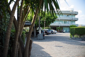 A parking area with cars and a building in the background. - Atlantis Palace Hotel (Mascali)