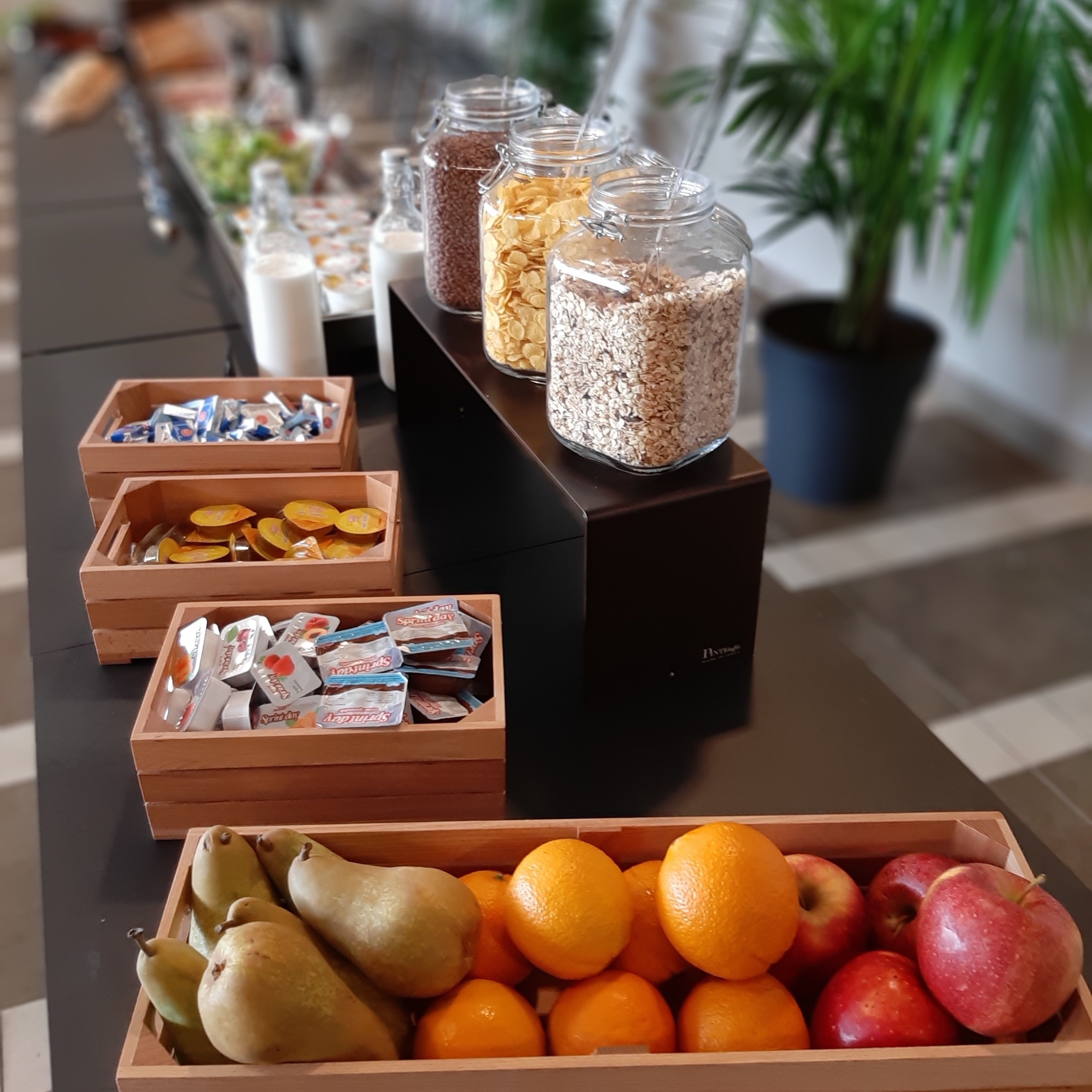 Bufet amb diversos aliments, com ara fruita, cereals i aperitius envasellats.