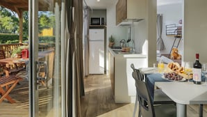A modern kitchen with a built-in microwave, a sink, and a small dining area with a table set for breakfast. - Fabulous Village (Rome)