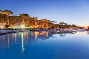 A serene pool area with lounge chairs and trees in the background. - Fabulous Village (Rome)