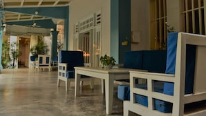 A spacious lobby with white furniture and blue accents, featuring a ceiling fan, large windows, and potted plants. - Amber Angkor Villa Hotel & Spa (Siem Reap)