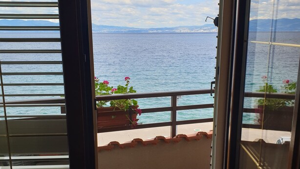 A balcony with a view of the sea and mountains.