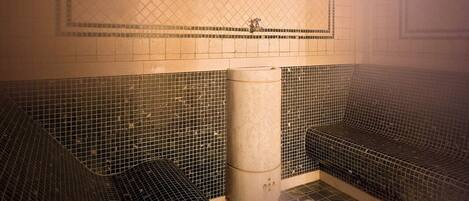 A room with a tiled floor, a central pillar, and a patterned wall.
