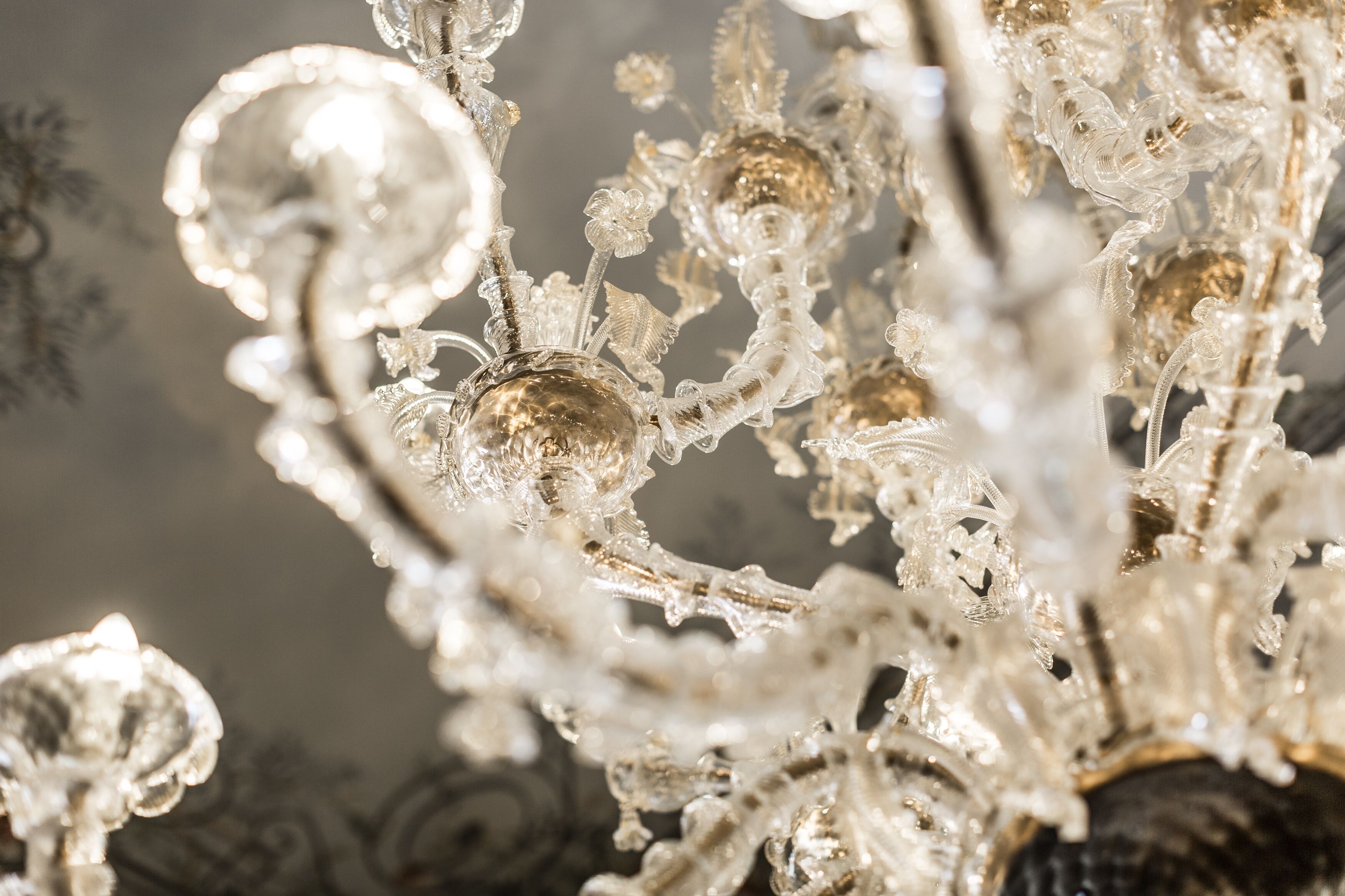 Un lustre orné de motifs complexes en cristal et doté d’une surface réfléchissante.