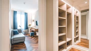 Un dormitorio moderno con sofá, mesita de noche y armario con iluminación integrada.