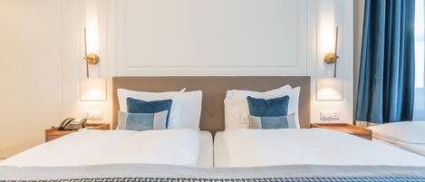 Ein Hotelzimmer mit einem großen Bett, zwei Nachttischen, einem Telefon und einem Beistelltisch.