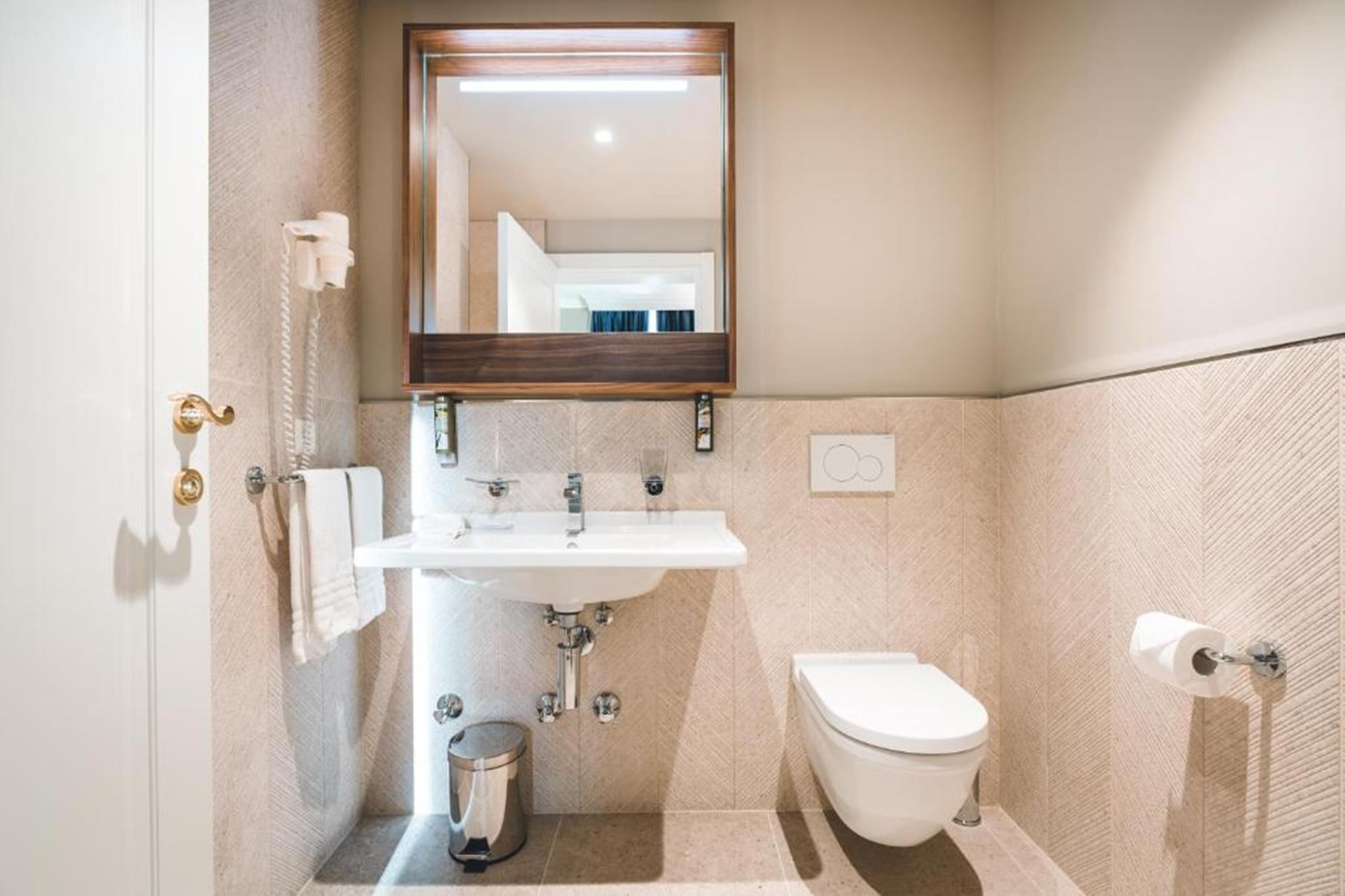 Ein Badezimmer mit Waschbecken, Toilette und Spiegel.
