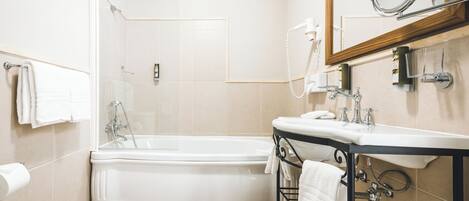 A modern bathroom with a freestanding bathtub, a vanity with a mirror, and a shower area.