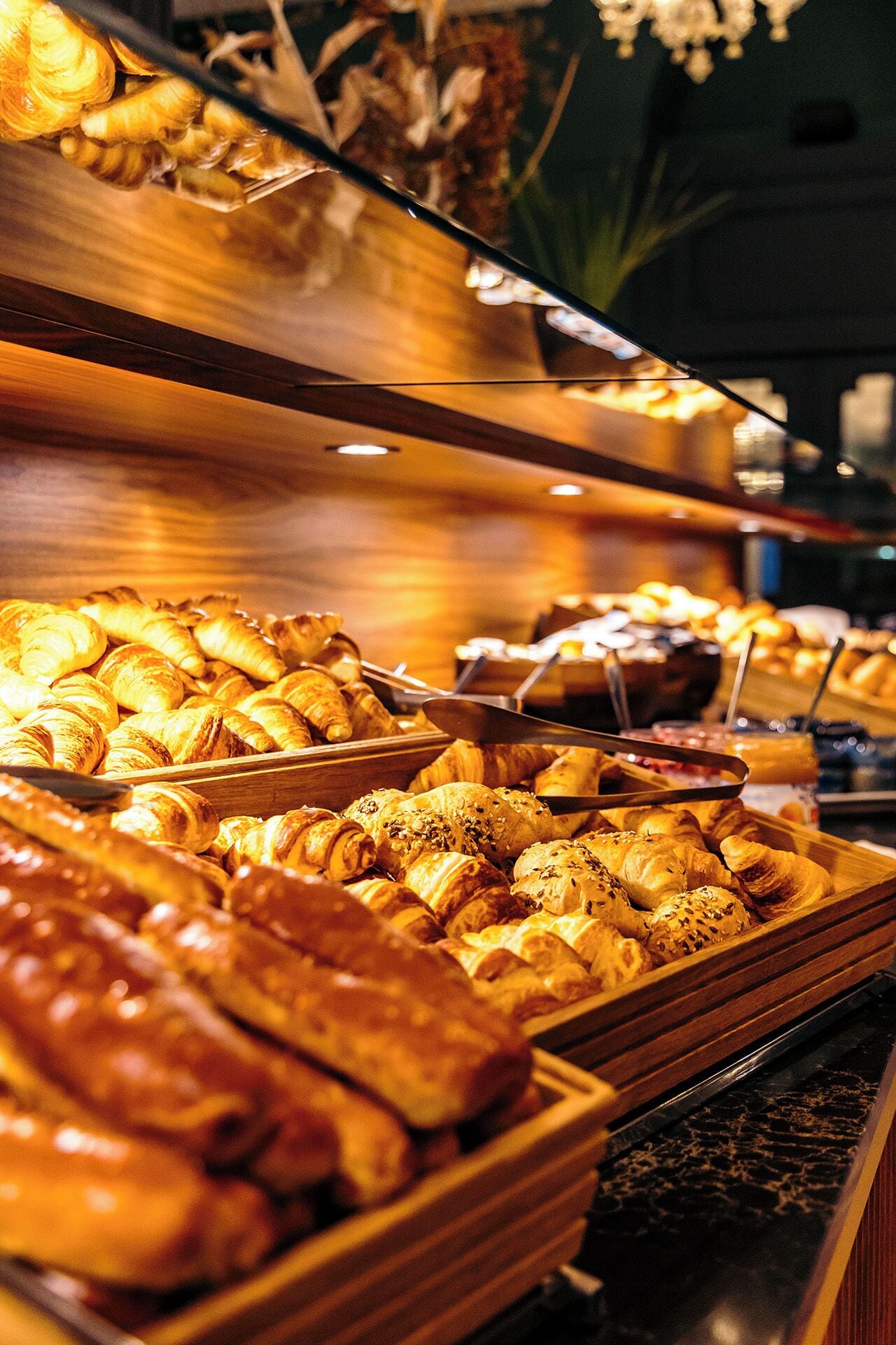 A buffet with various baked goods like croissants and bread.
