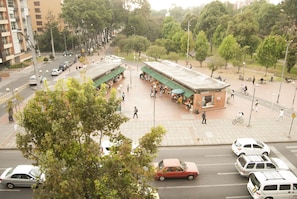 A busy urban street with a central plaza, buildings, and trees. - Jazz Apartments Luxury Suites (Bogotá)