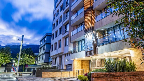 A multi-story hotel with a modern design, featuring balconies and a well-lit entrance. - Jazz Apartments Luxury Suites (Bogotá)