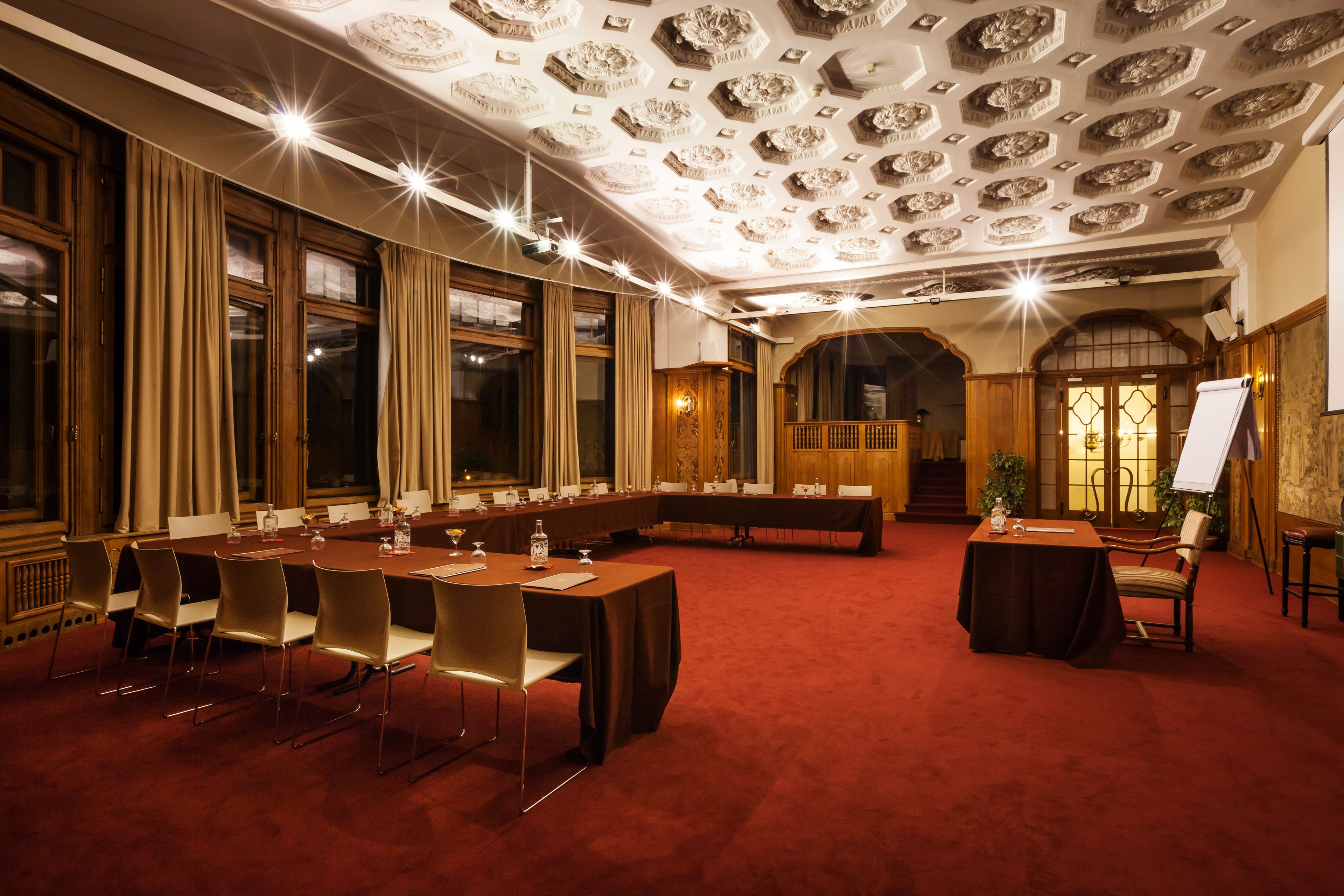 Un salón de conferencias con una larga mesa, sillas y una pizarra.