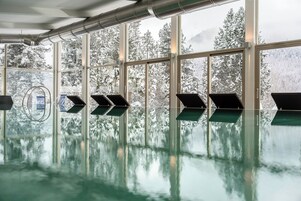 Una piscina techada, sillones reclinables de piscina