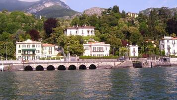Blick auf das Wasser mit einer Brücke, Gebäuden und Bergen im Hintergrund.