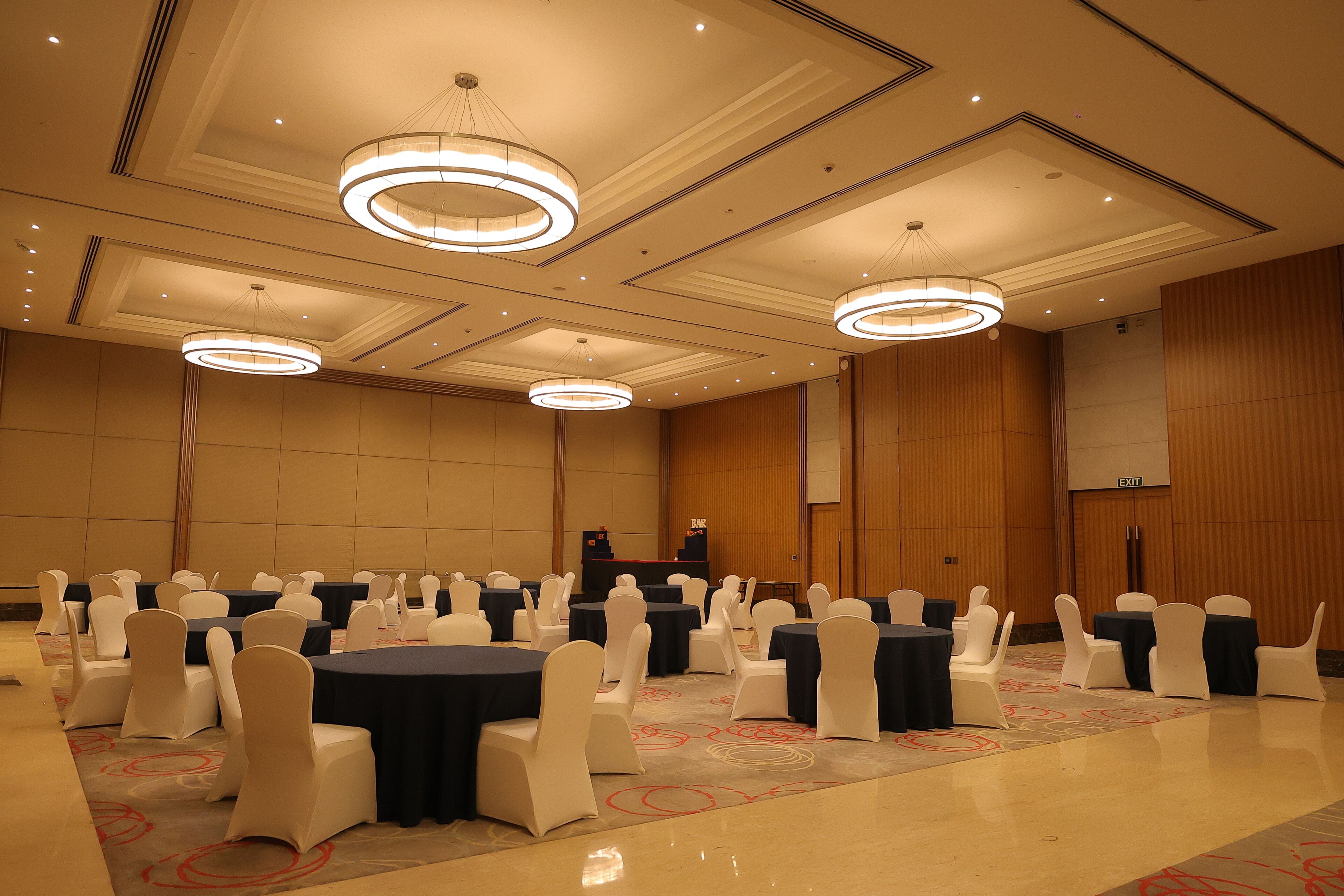 A conference room with round tables, white chairs, and a podium.