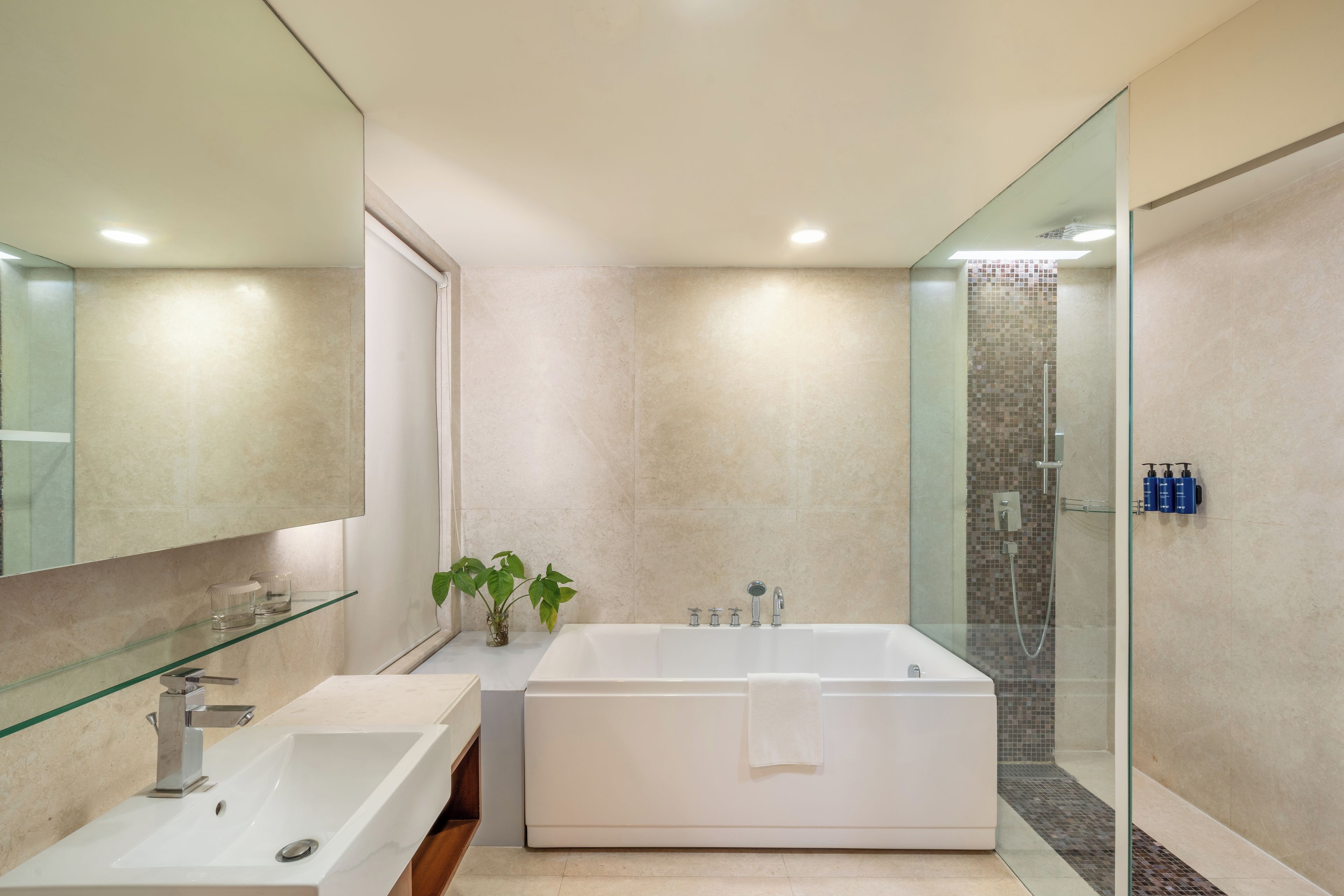 A modern bathroom with a freestanding bathtub, a glass shower enclosure, and a large mirror.