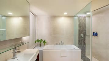 A modern bathroom with a freestanding bathtub, a glass shower enclosure, and a large mirror.